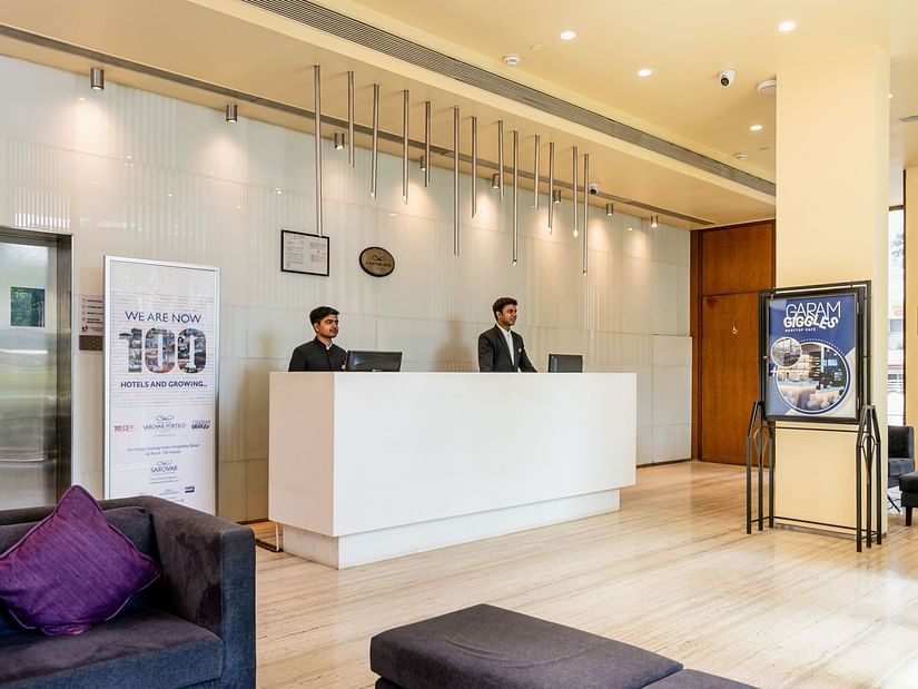  Two people standing at reception in Marasa Sarovar Portico, Rajkot