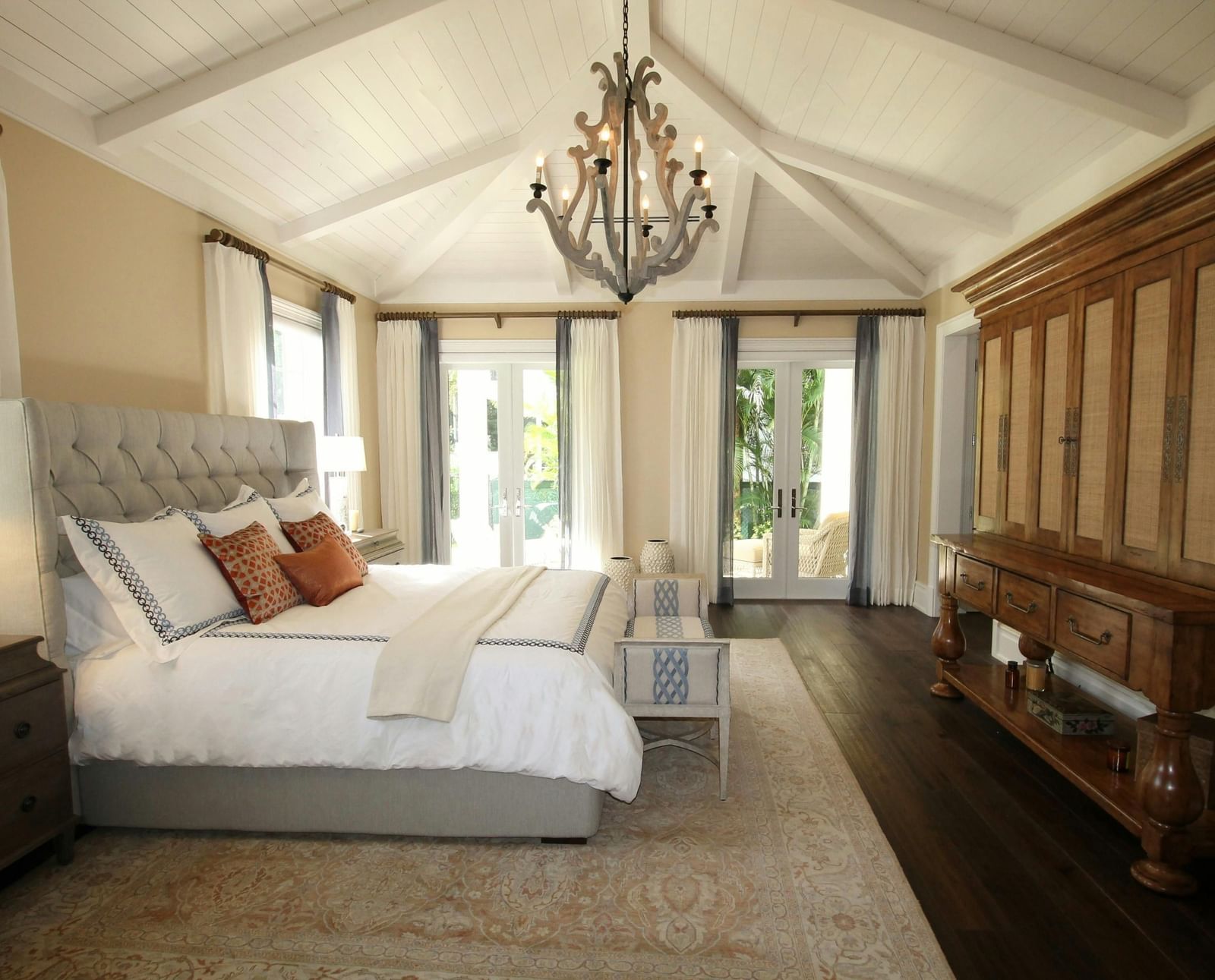 Side view of the bed with a chandelier hanging over the double bed.