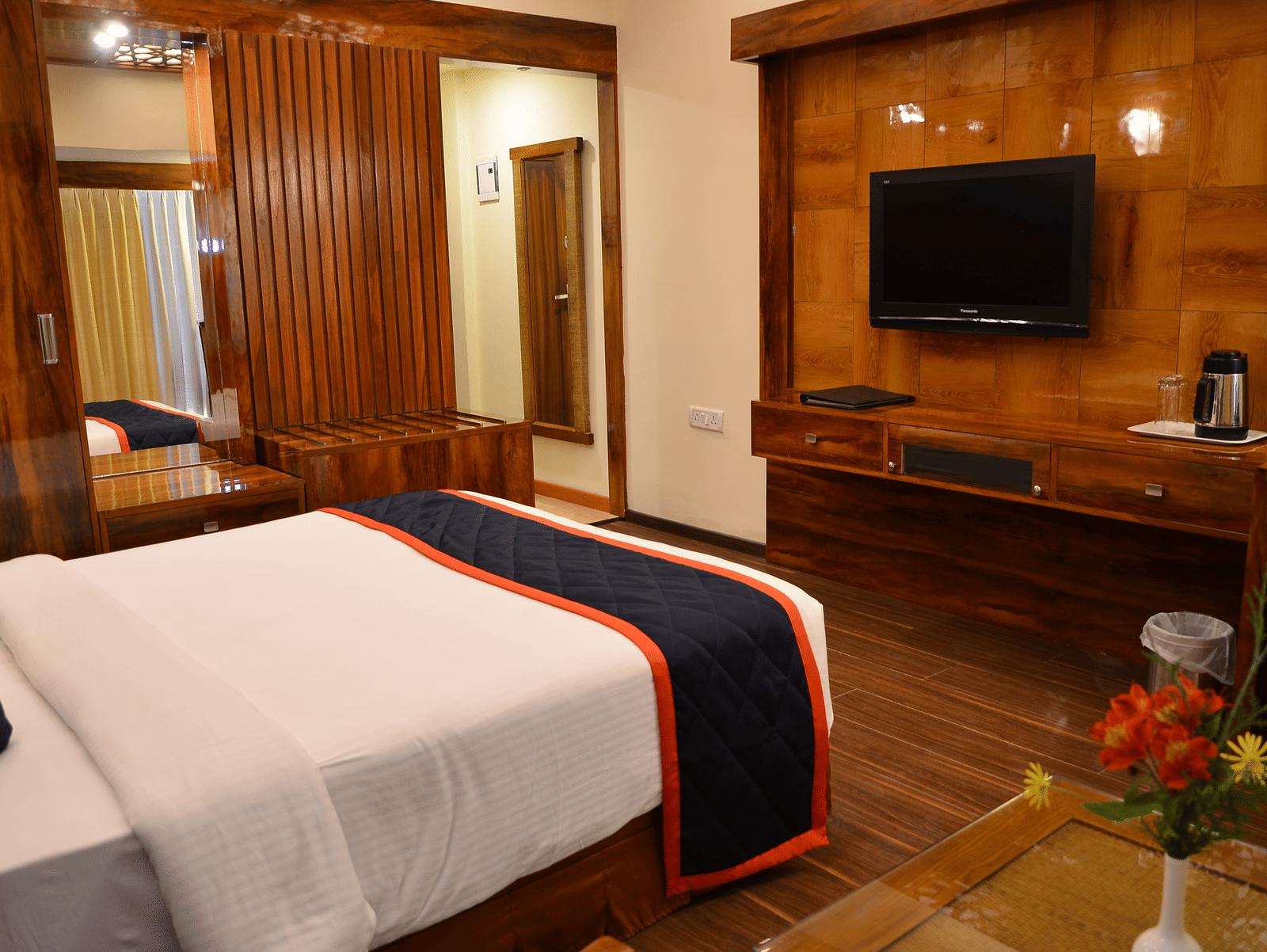 A cosy room with a queen bed, wooden panelling, and wall-mounted TV for a relaxed stay - Benzz Park, Kodaikanal