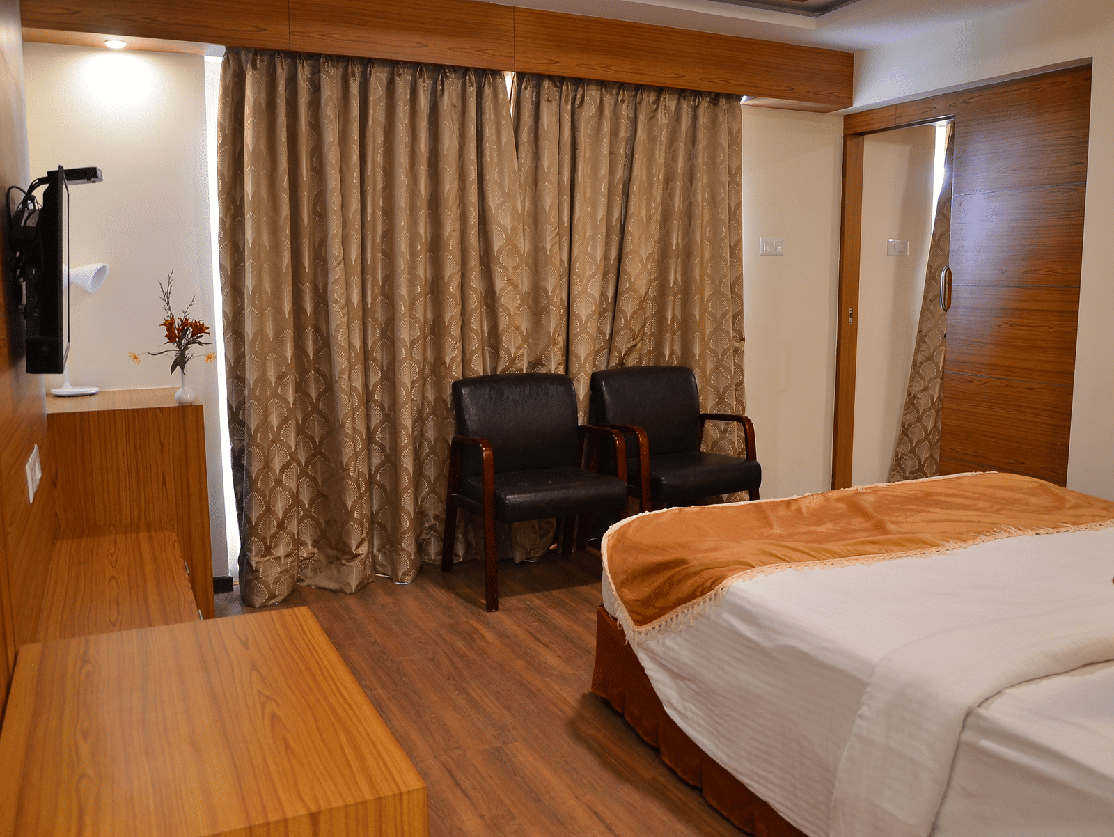 A room with a single bed, TV, and two chairs neatly arranged - Benzz Park, Kodaikanal