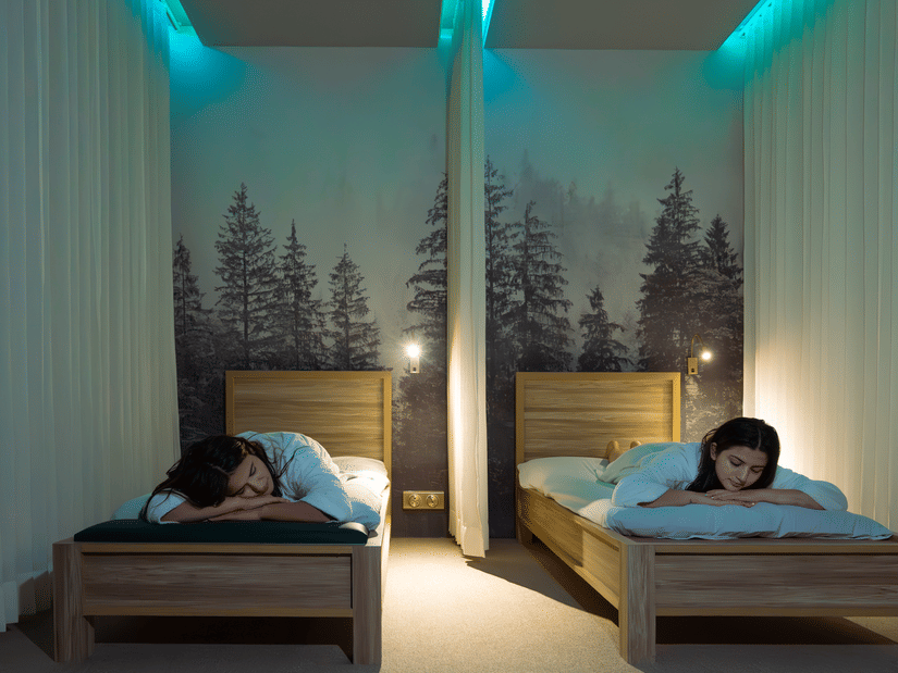 Tranquil quiet room with twin massage beds, forest mural backdrop, and ambient lighting at The Manor Wellness & Sports Hotel