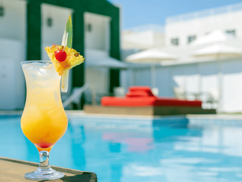 A cocktail with a fruit peel by the side of the pool - S Hotel Kingston, Jamaica