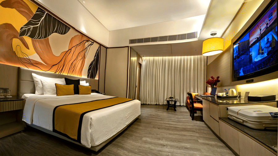 Premium guest room with king bed, modern artwork and warm lighting at The Sonnet, Jamshedpur.