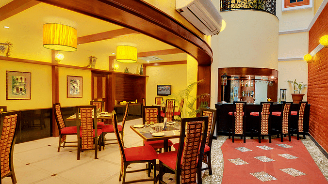 Bistro - multicuisine restaurant in Puducherry featuring tables arranged with chairs under warm ambient lighting