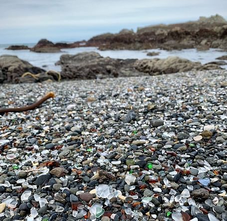 A close up image of glass stones and other rolling stones near the beach
