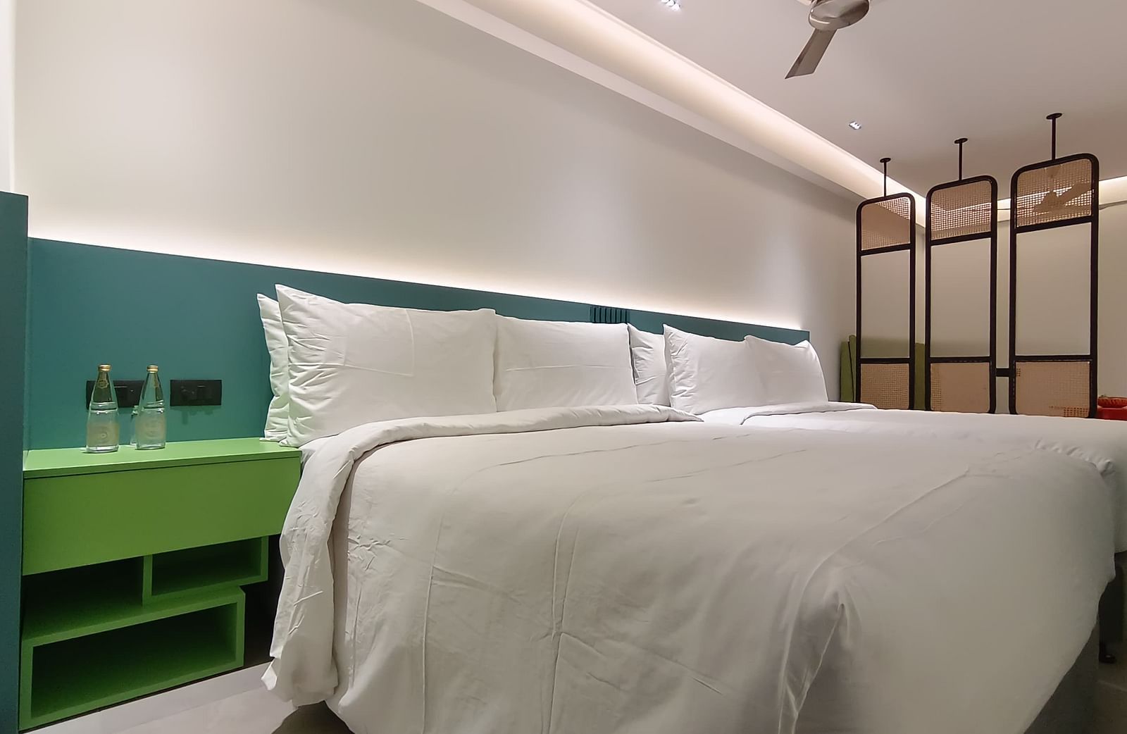 Vibrant bedroom with colourful interiors and a neatly made large bed