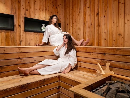 An image of two women sitting in a wooden platform in a wooden room  - The Manor Luxury Hotel, Shimla