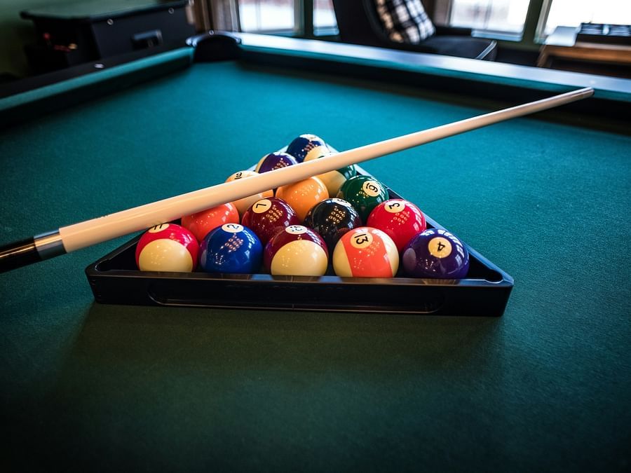 An image of billiard with balls and a stick