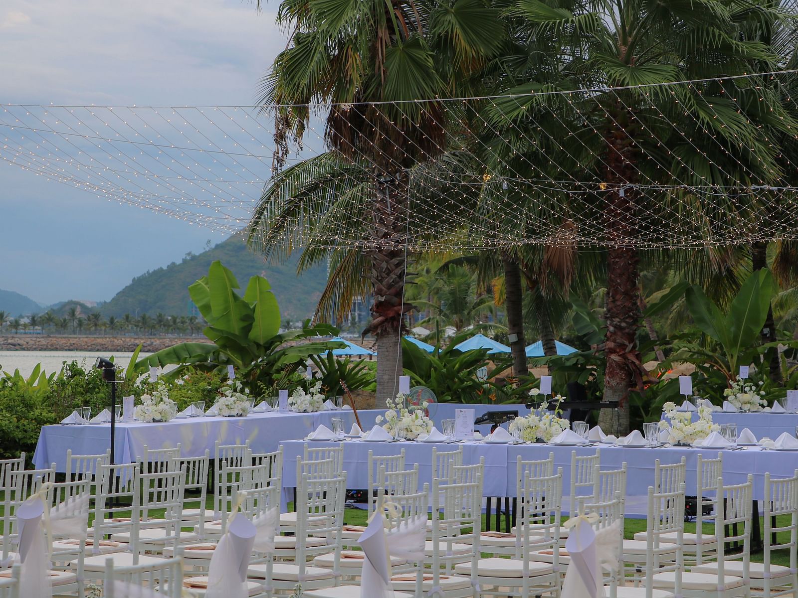 A view of the lawn with white chairs and hanging lights above the chairs - Alibu Resort Nha Trang