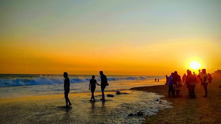 people standing by a beach during sunset