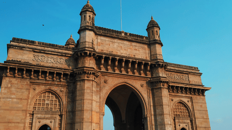 A close up of the gateway of India with blue sky in the background - a must-visit on your day outing in Mumbai.