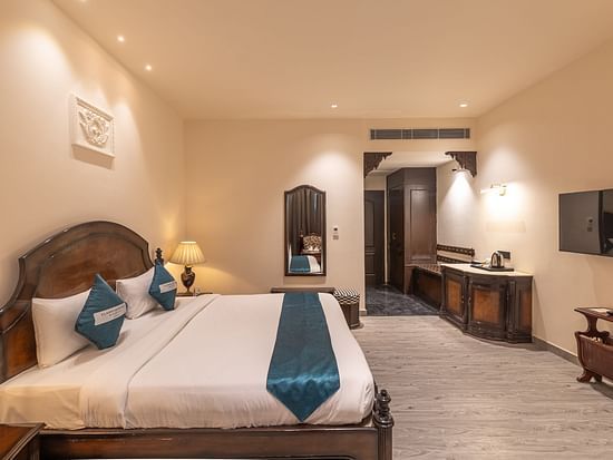 Well-appointed guest room with writing desk and TV at Clarks Resort The Archi's Castle, Ajmer.