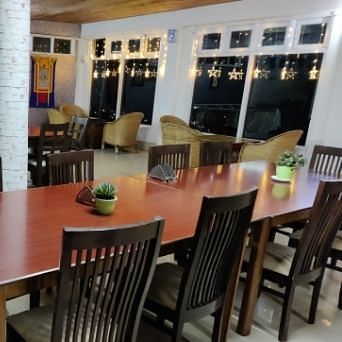 A restaurant seating area with table and chairs, lights set for diners