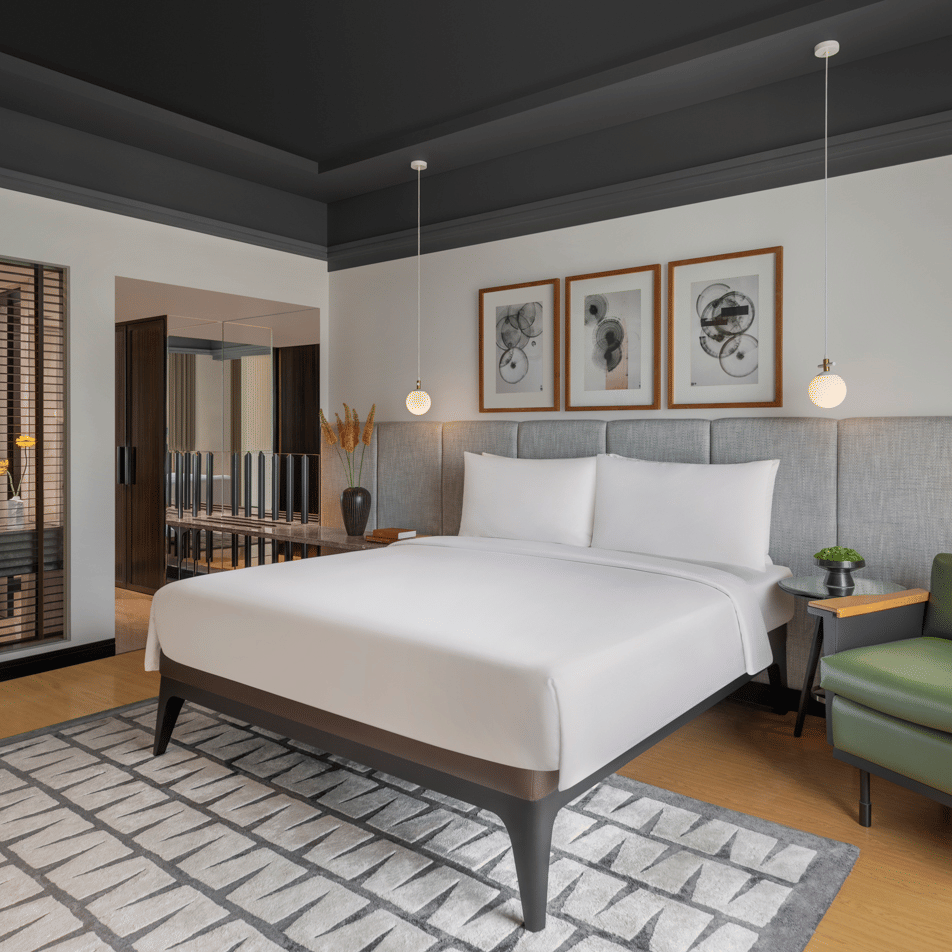 Bedroom with large bed, seating area, and windows at The Raintree, St. Mary’s Road.