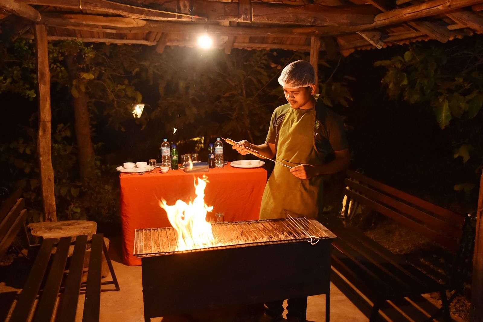 An intimate dining experience at Forest Escapes Koyna, with a softly lit table set for two in a rustic setting.