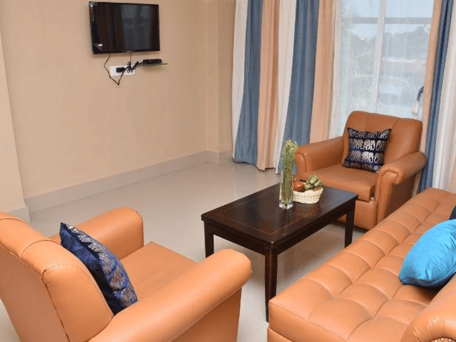 Sitting room at Central Courtyard Boutique Hotel, Siliguri, featuring a sofa set arranged aroun a coffee table with a vase on it
