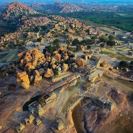 Aerial view of Hampi ruins and rocky landscape at sunset.