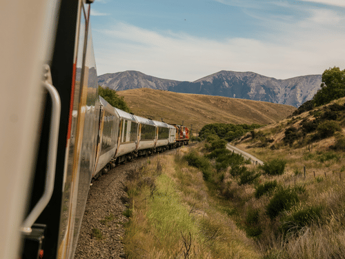 A train running on a track with hills in the background