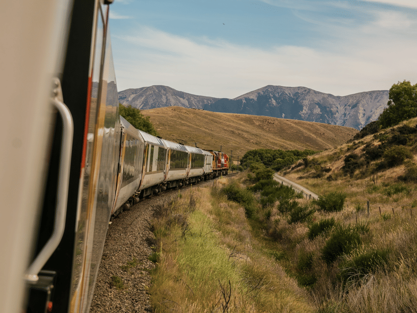 A train running on a track with hills in the background