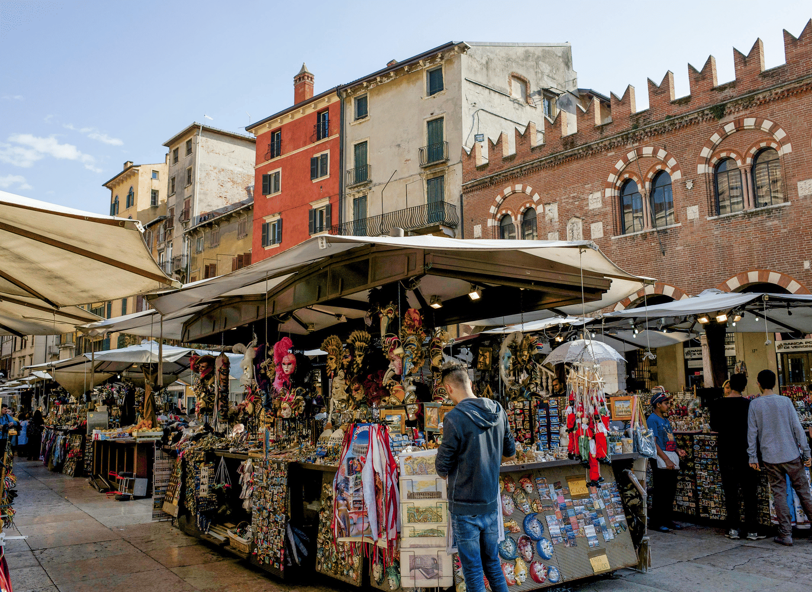 A street market selling several souvenir items on a bright day with a clear blue sky in the background