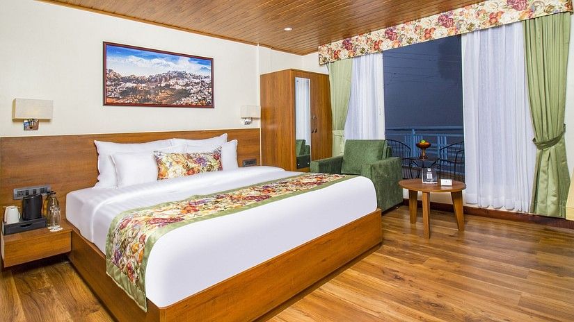 Side view of Suite With Balcony room with a cosy bed at Mount Lungta Boutique Hotel & Spa