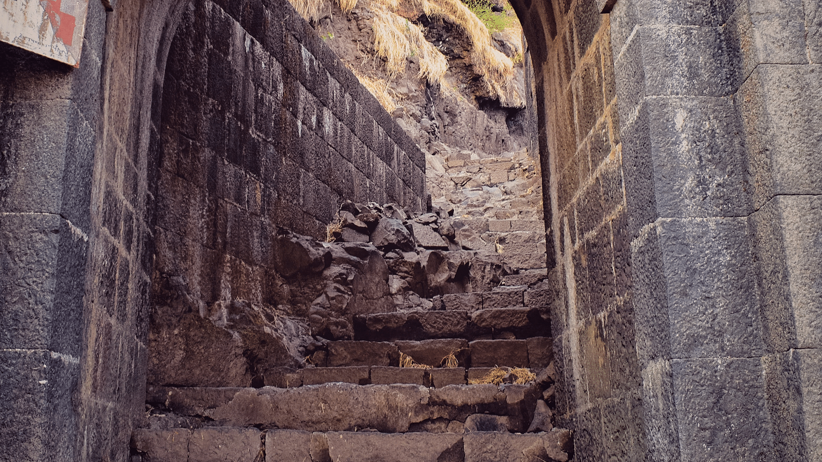 a close up shot of a stone archway with steps leading inside