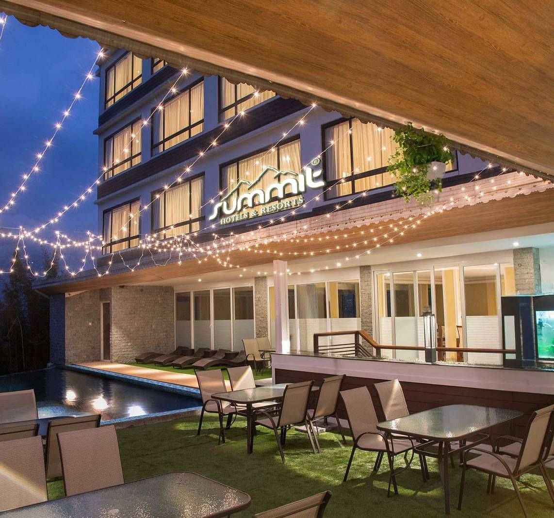 A pool side dining arrangement illuminated by hanging lights - Summit North Star, Gangtok