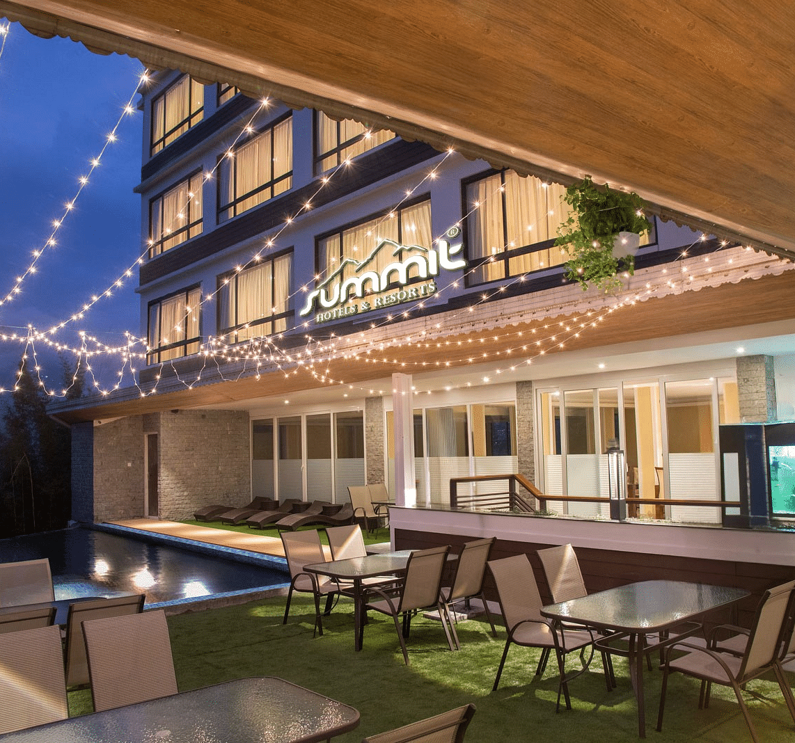 A pool side dining arrangement illuminated by hanging lights - Summit North Star, Gangtok