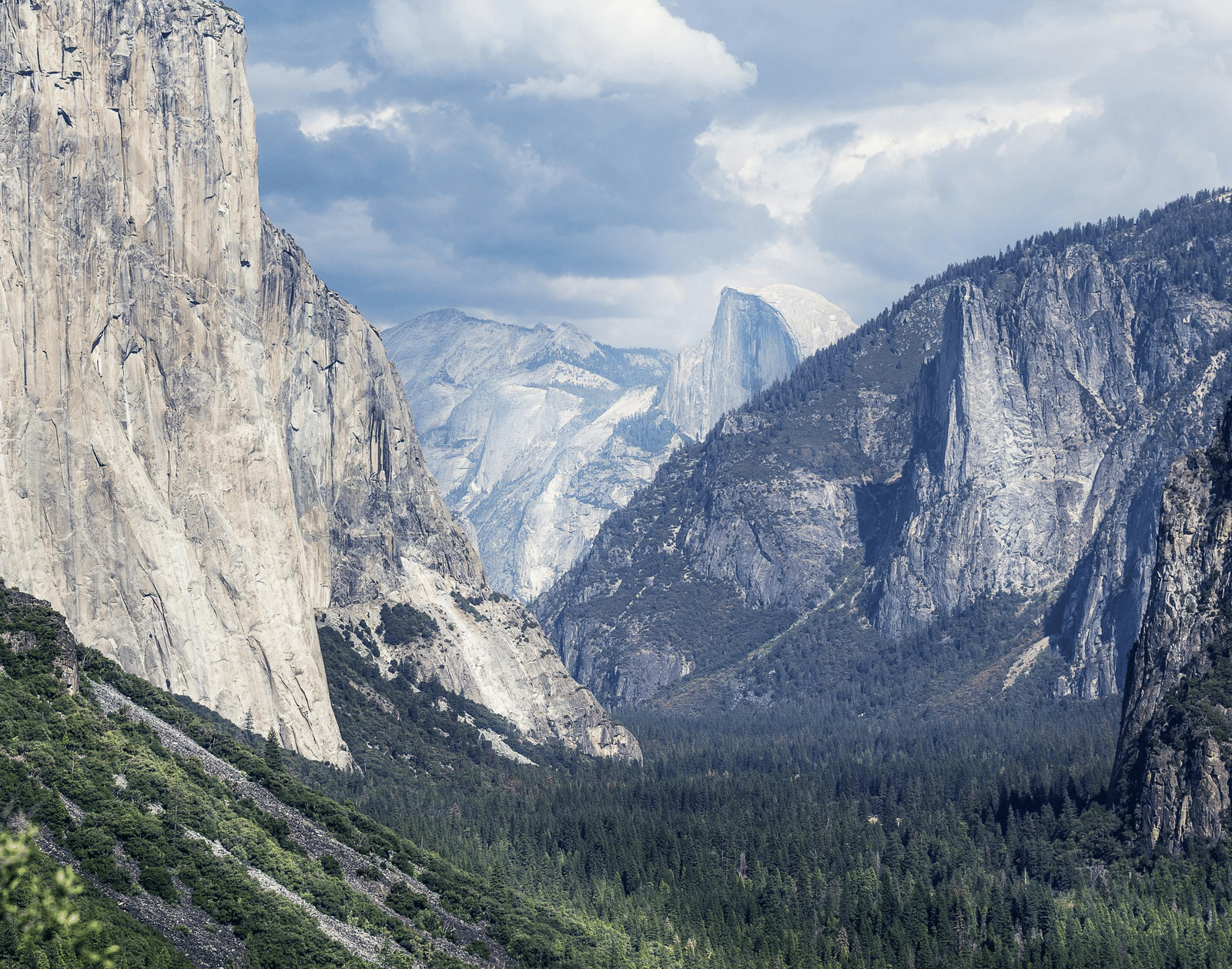 A valley at Yosemite National Park with snow-capped mountains in view.