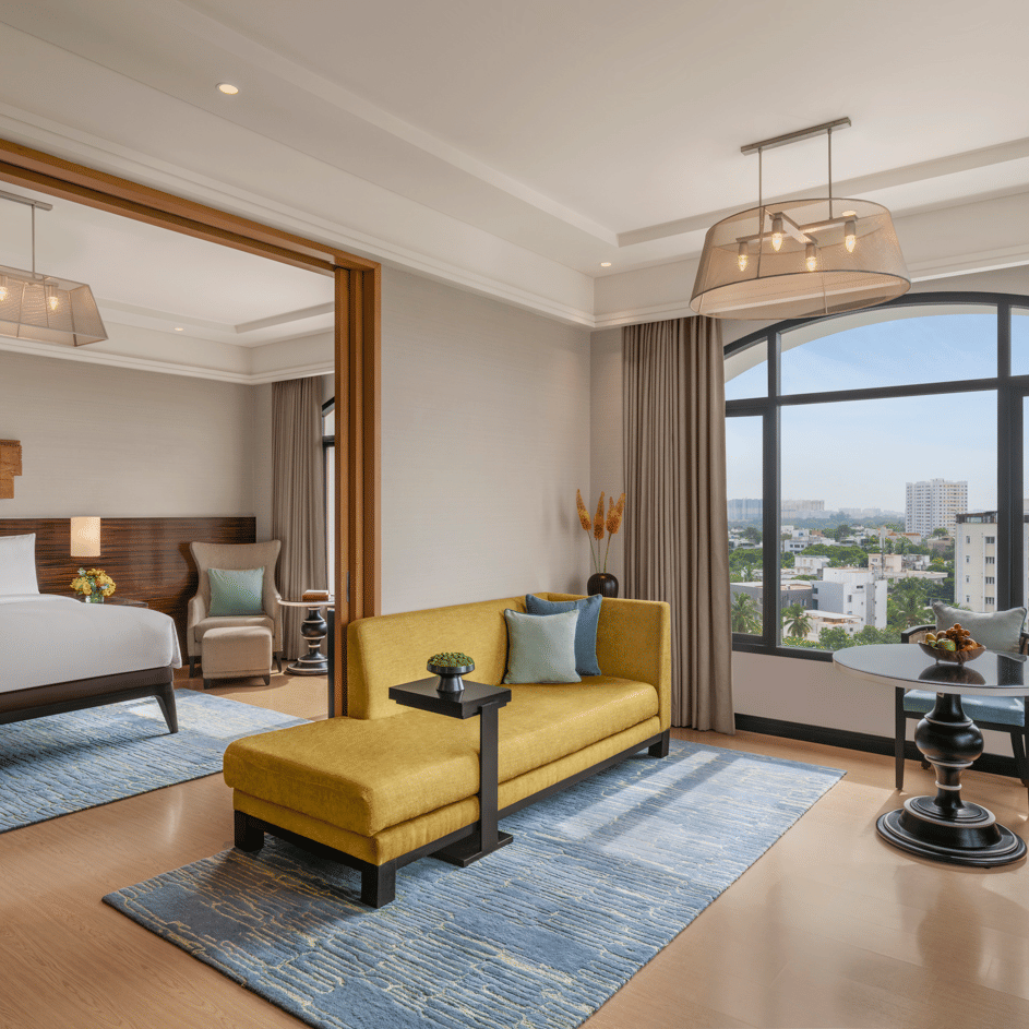 Bedroom with bed, desk, and side chair near windows at The Raintree, St. Mary’s Road.
