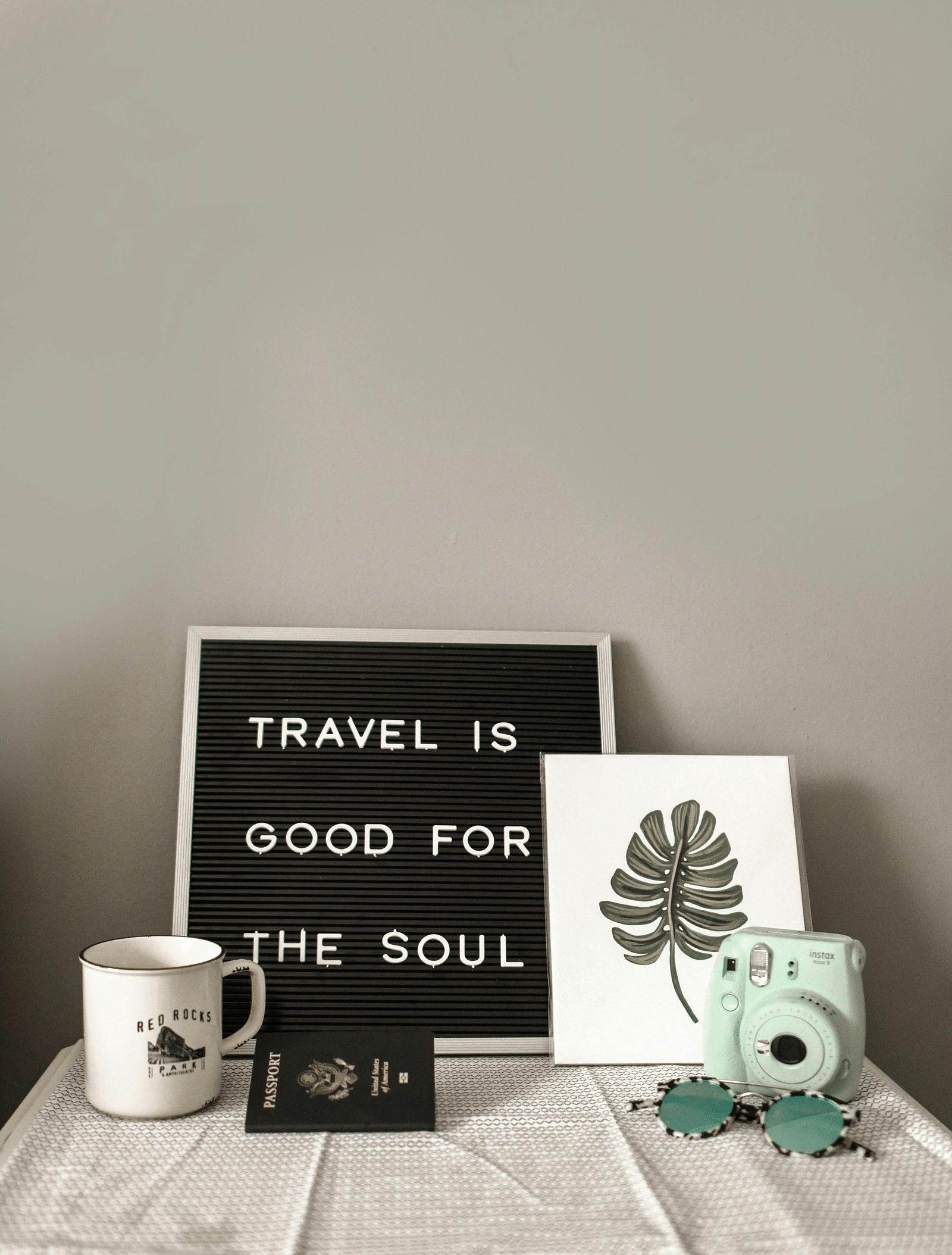 Image of a small black board which features a quote about travel.