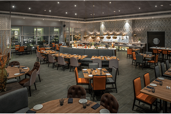 Restaurant at The Residency Towers Rameswaram featuring dining tables and chairs