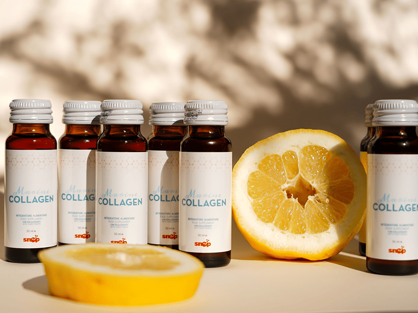 Bottles of marine collagen supplement beside halved lemons