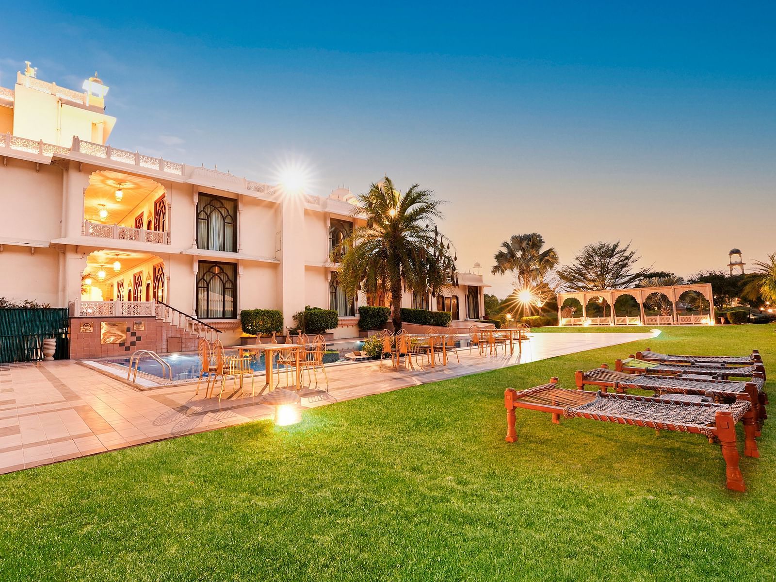 Lawn area with a sit out in front of the building in the night - Rajasthali Resort & Spa, Jaipur.