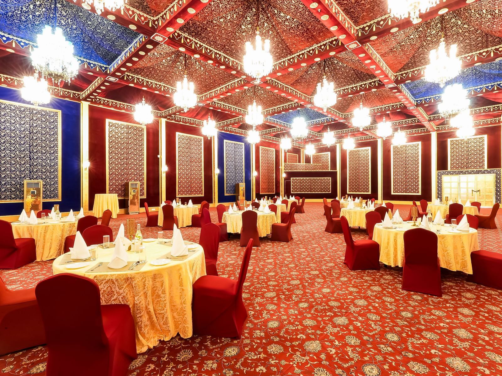 An overview of a plush banquet hall with round table seating - Rajasthali Resort & Spa, Jaipur.