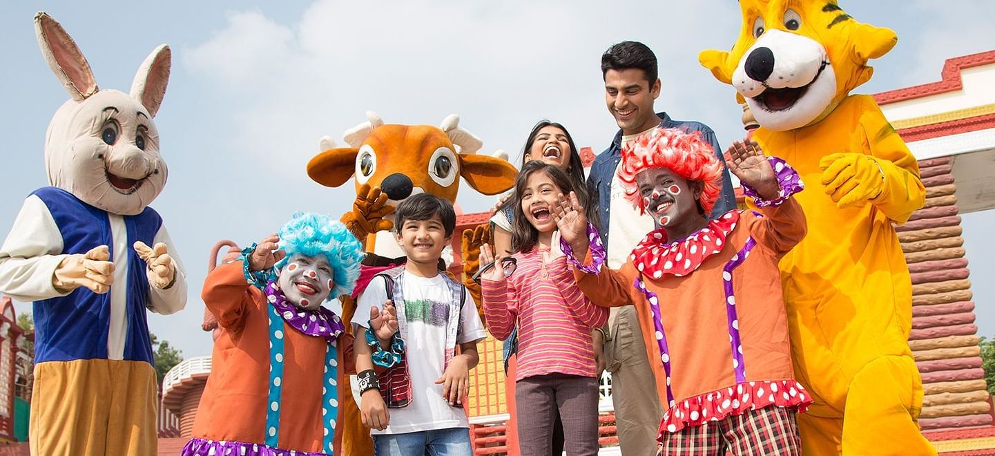 A family looking enthusiastic at Ramoji Film City with the mascots