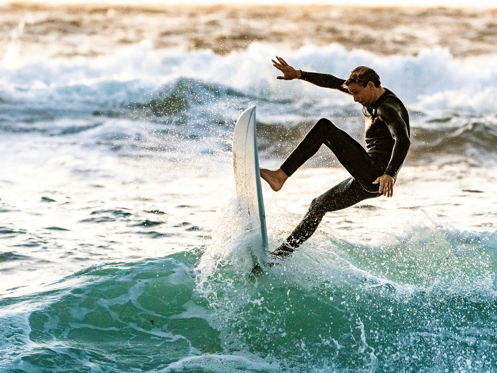 A man rides a wave on his surfboard in the open sea.