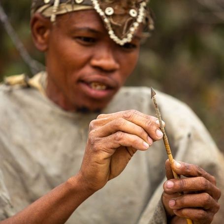 An African man examining an arrow.