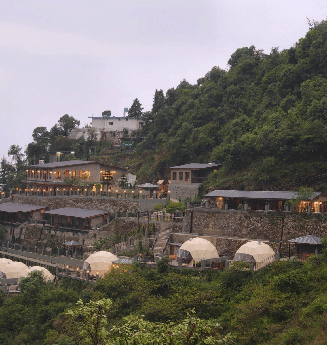 Panoramic view of Samsara Hill Resort nestled amidst the lush green hills of Mussoorie, showcasing the resort’s tranquil mountain setting.