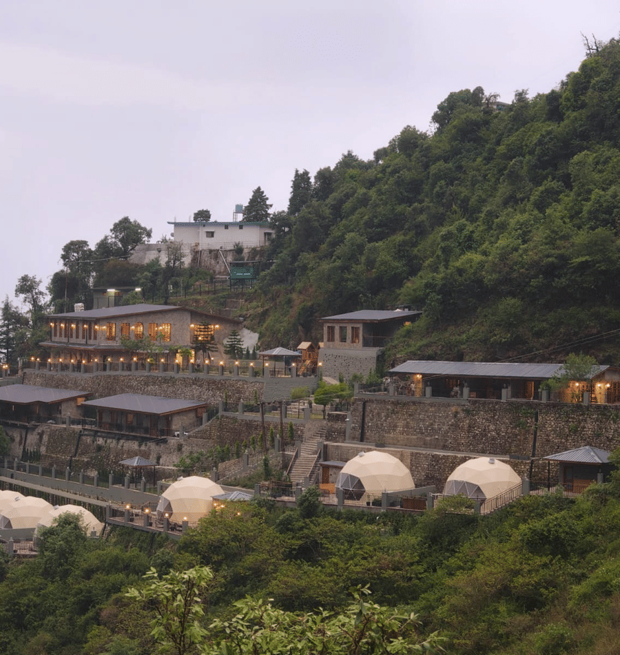 Panoramic view of Samsara Hill Resort nestled amidst the lush green hills of Mussoorie, showcasing the resort’s tranquil mountain setting.