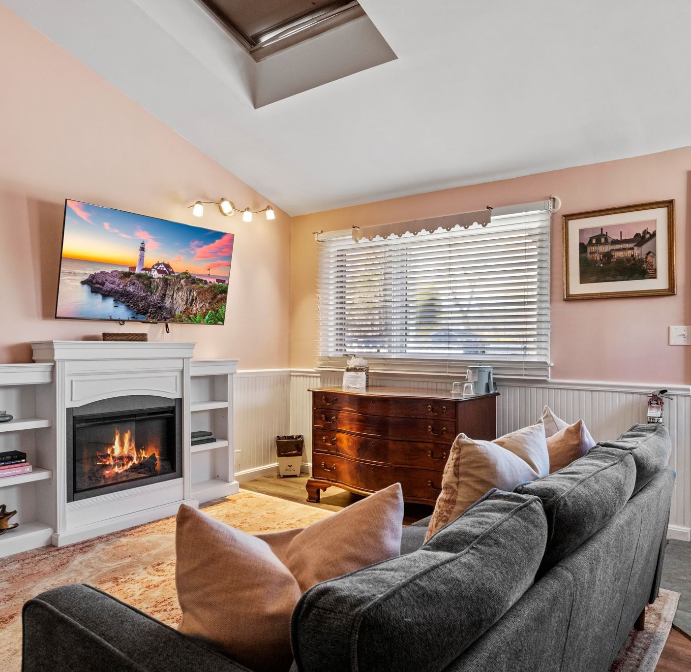 Living room with fireplace, flat screen TV, and large window at Hartstone Inn