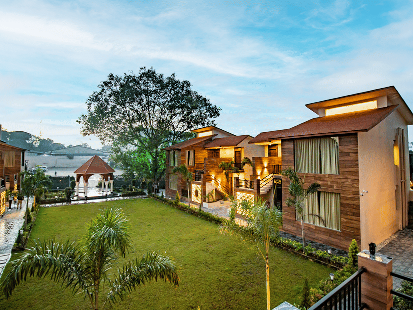 A scenic view of our hotel nestled near the lush lawn beneath the expansive open sky - Wedlock Greens Hotel & Resorts