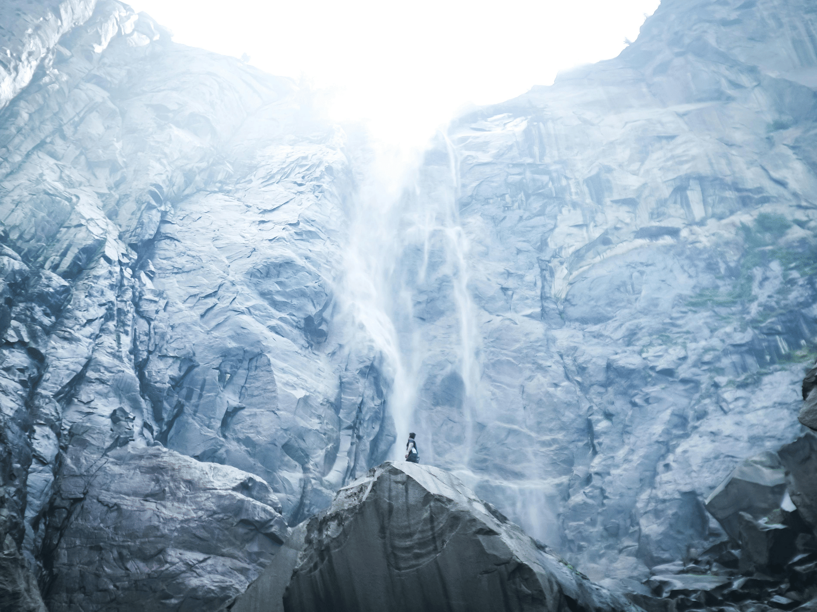 A frozen waterfall surrounded by large ice-covered rock walls.