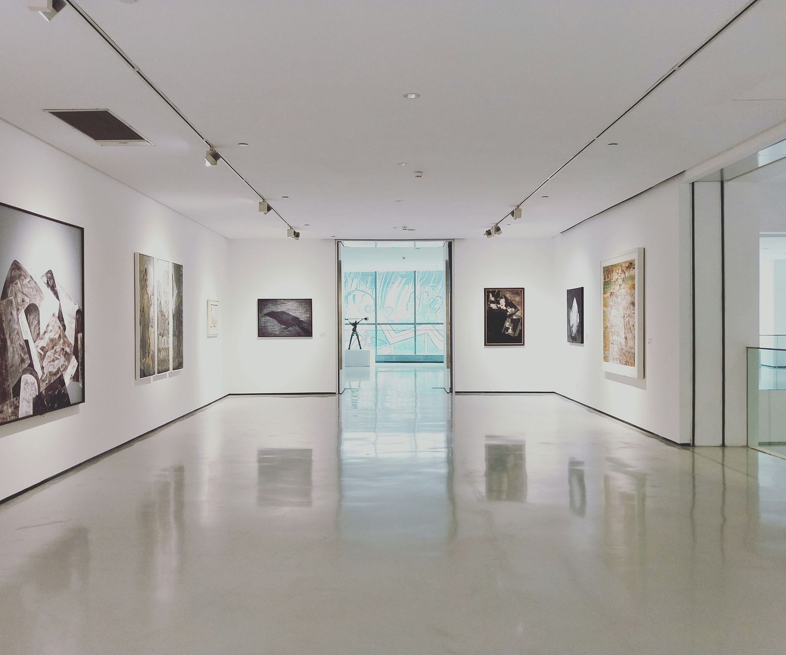 An overview of a museum with painting hung on all sides of the walls