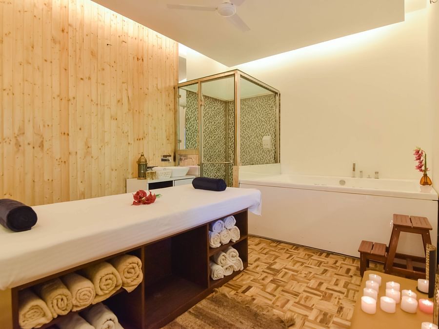 A relaxing spa room with a massage table and candles.