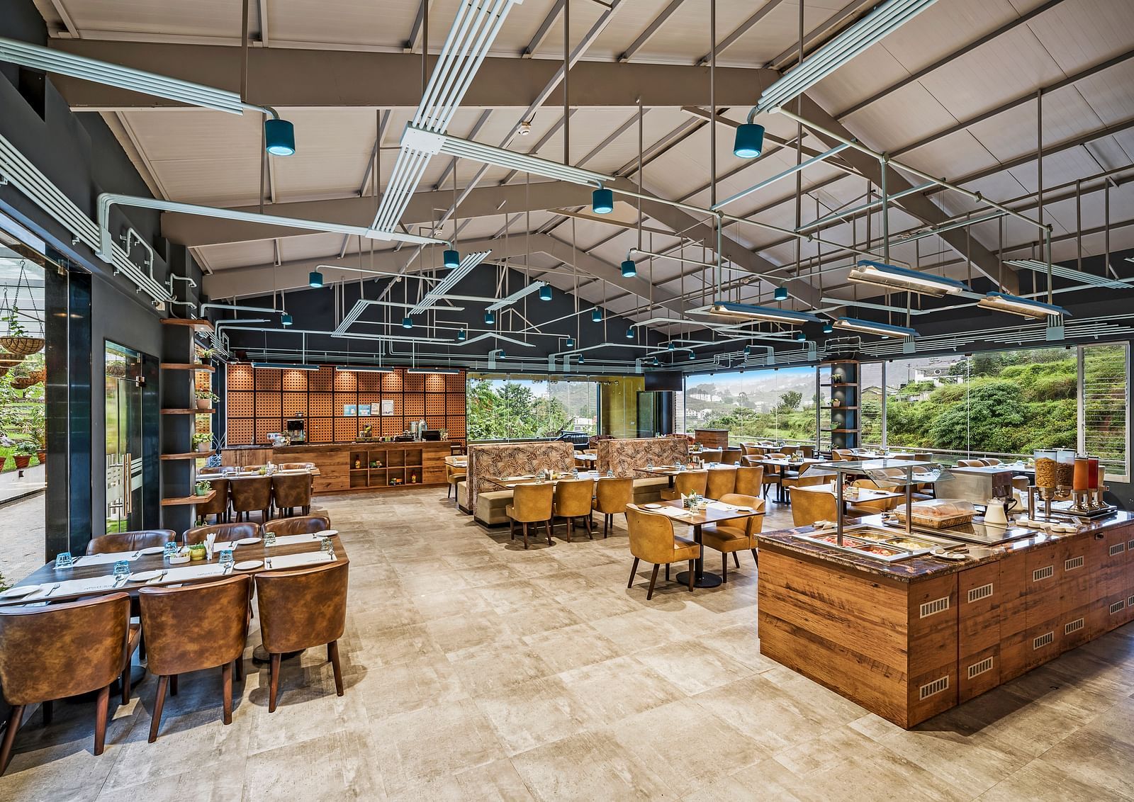 An image of a restaurant with seating arrangement and views of the valley - GReaT Trails Kodaikanal By GRT Hotels