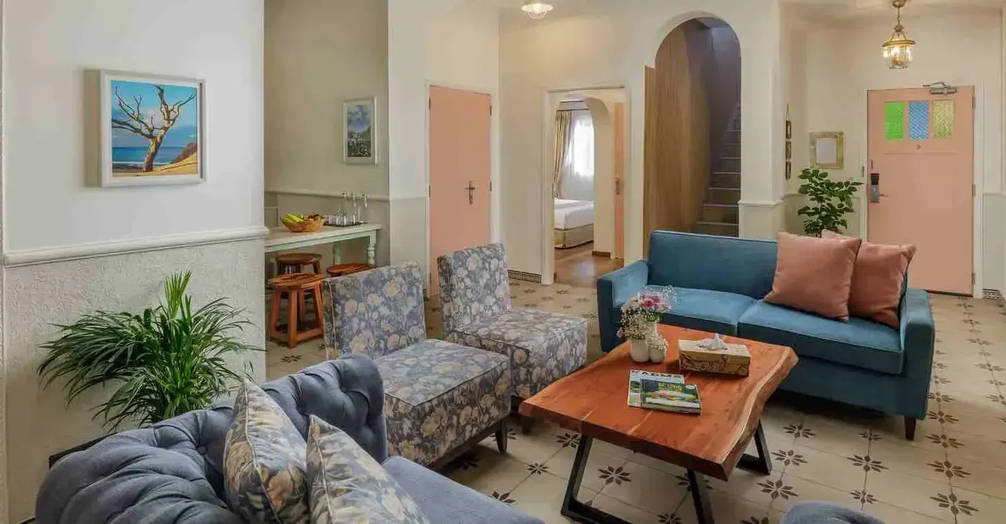 Indoor lounge with armchairs, sofas, and wall art at Karma Chalets, the best pet-friendly resort near Delhi.