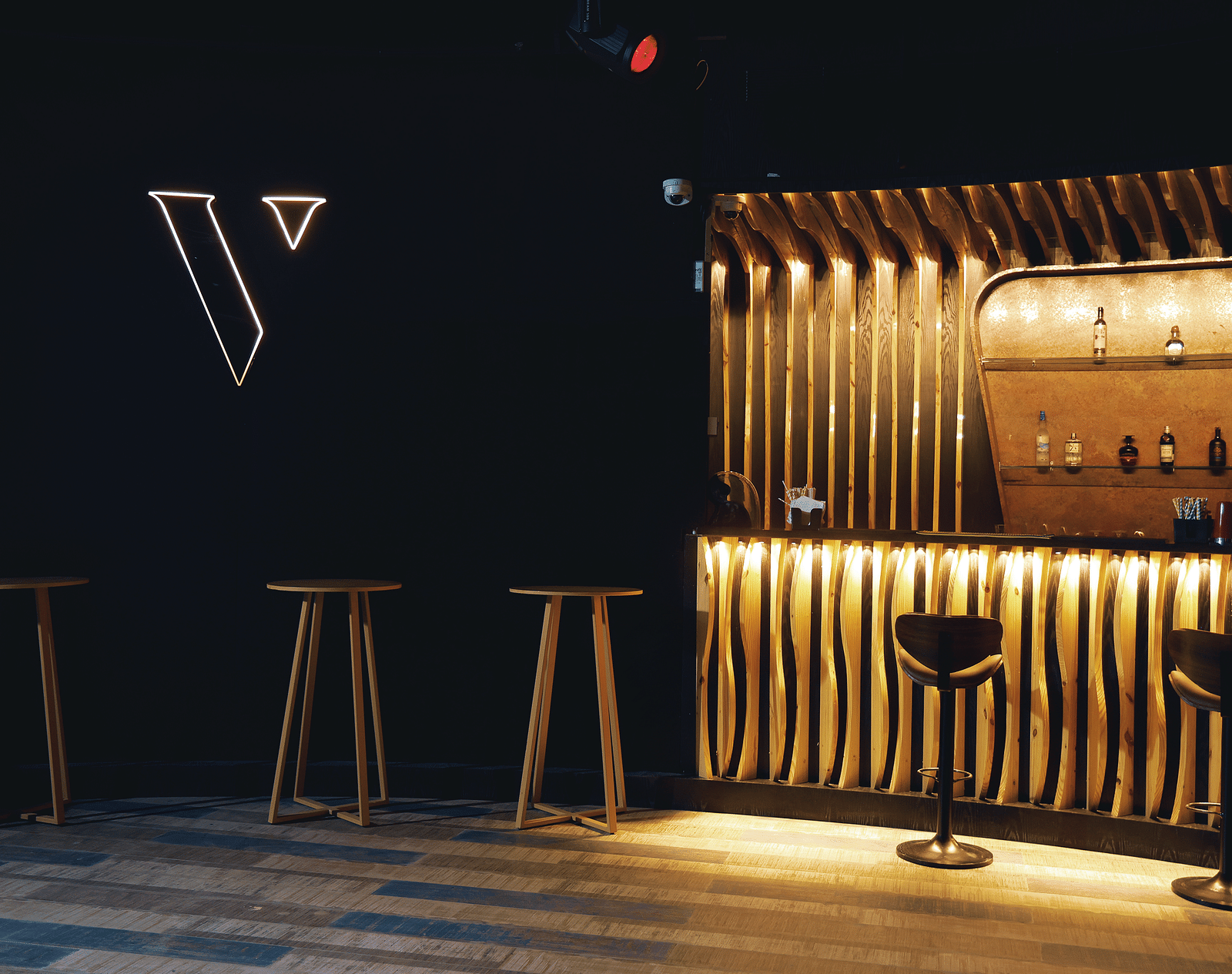 Verve featuring a minimalist logo, warm lighting, and sleek wooden bar stools at The Qualia Resort Club & Brewery, Udaipur.