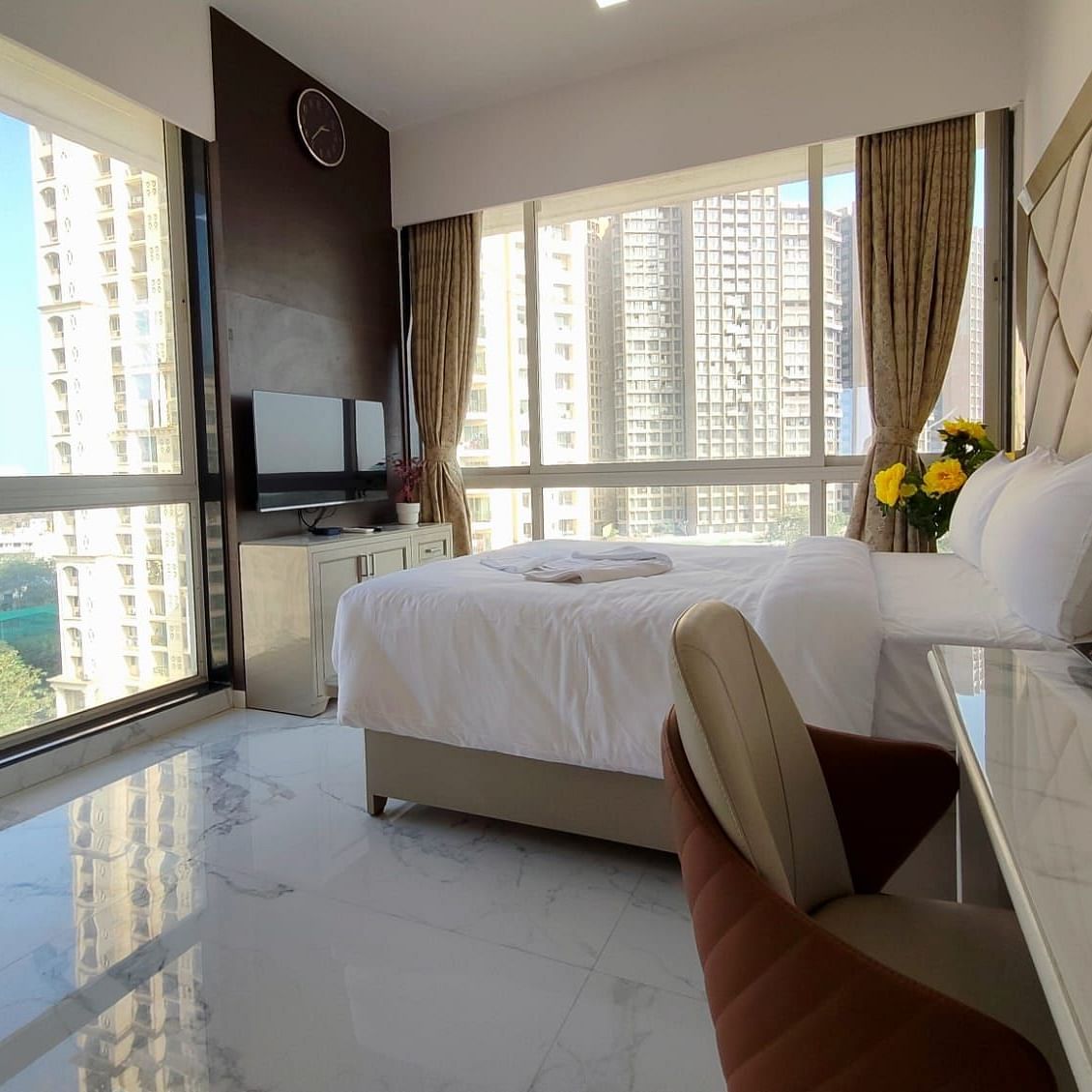 deluxe room at Maxxvalue Hotel, Chitranjan Tower, Powai with a posh bed and white linens along with floor-to-ceiling windows offering ciy view2