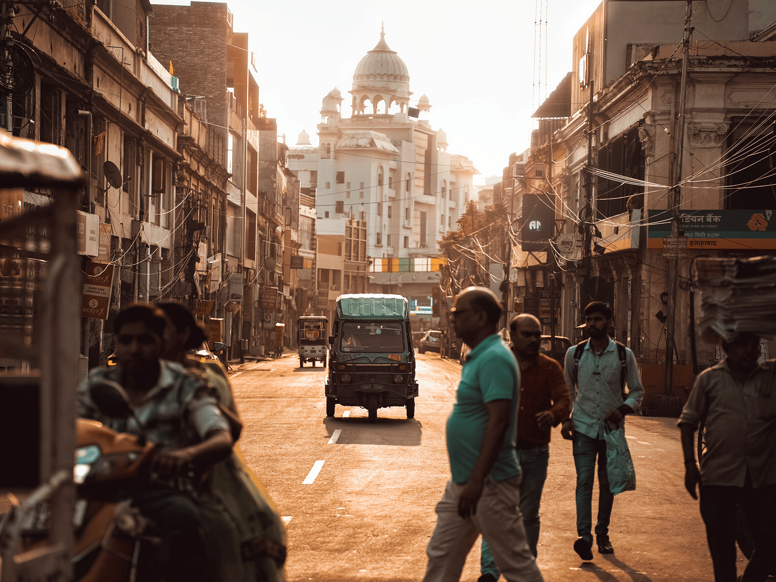 people crossing a road near a market in Lucknow